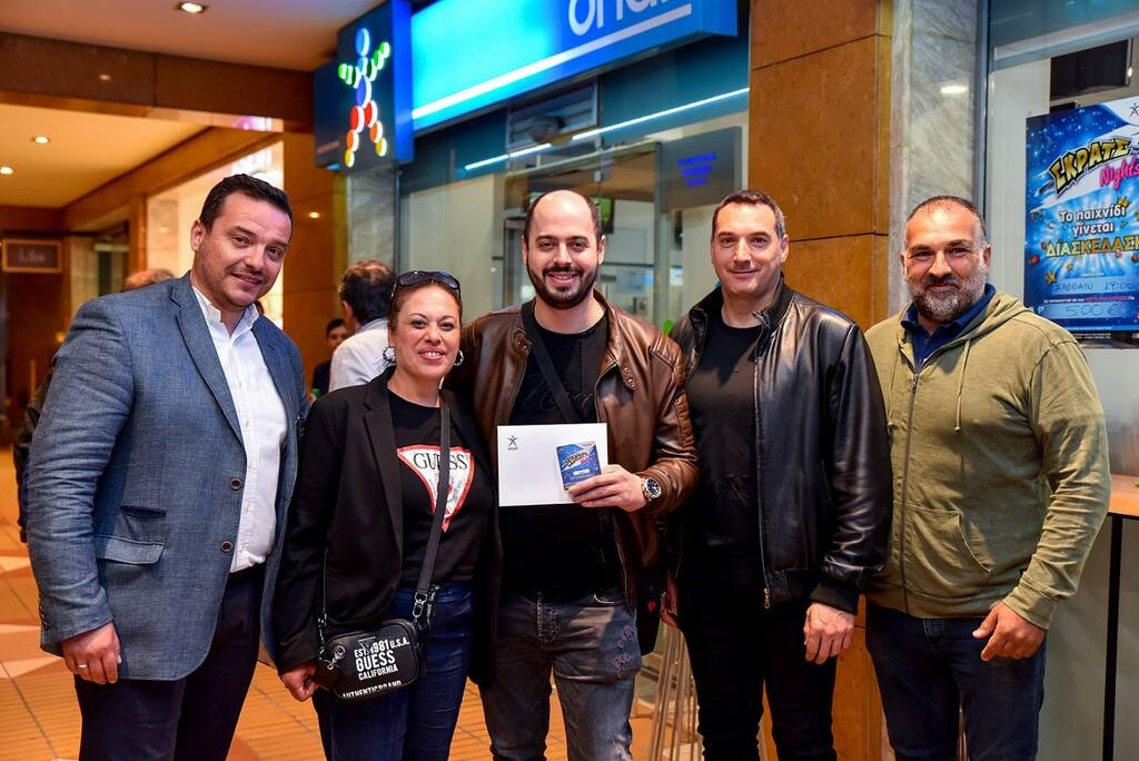 Ο νικητής της κλήρωσης με τον ιδιοκτήτη του καταστήματος ΟΠΑΠ και την ομάδα του ΟΠΑΠ